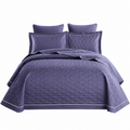 Purple quilt set with matching pillows on a white background
