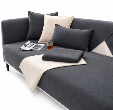 Gray sofa with cushions and a blanket on a white background