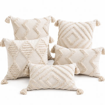 Set of decorative pillows with geometric patterns and tassels on a white background